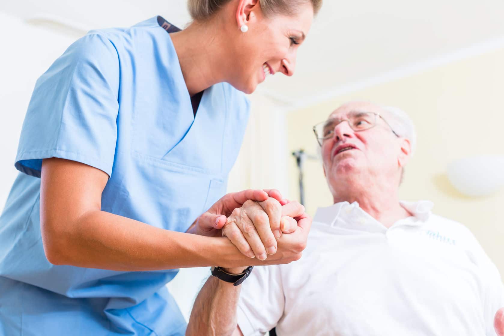 47846451 - nurse holding hand of senior man in rest home
